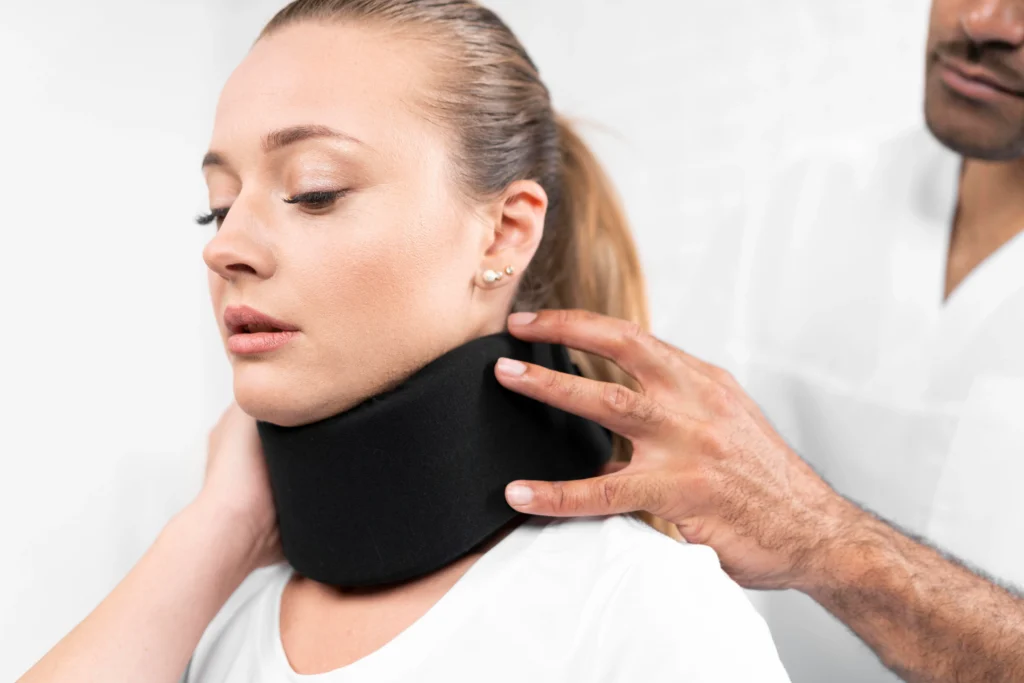 A medical professional fitting a black cervical neck collar on a woman, representing a California whiplash injury claim handled by Protection Law Group.